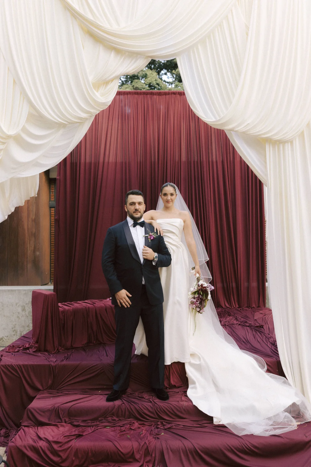 Manuela and Juan Pablo under the burgundy drapes